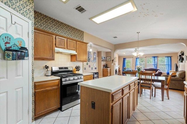 4125 Licorice Ln, Austin, TX 78728 - kitchen featuring stainless steel range with gas stovetop, under cabinet range hood, arched walkways, open floor plan, and light countertops