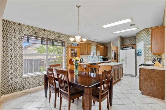 4125 Licorice Ln, Austin, TX 78728 - dining room with wallpapered walls, a chandelier, light tile patterned flooring, and baseboards