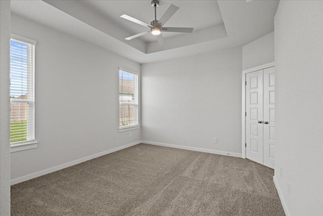 240 Camino Verde Dr, San Marcos, TX 78666 - carpeted spare room with a ceiling fan, a tray ceiling, and baseboards