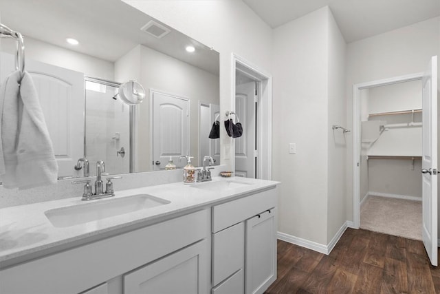110 Saide St, Georgetown, TX 78626 - full bathroom with a stall shower, a spacious closet, double vanity, wood finished floors, and baseboards