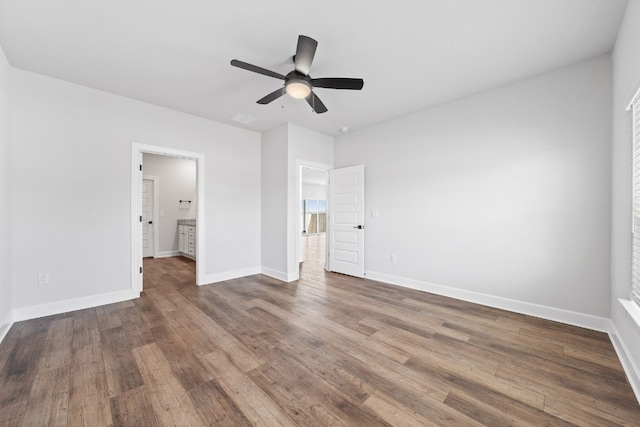 17012 Wind Chime Dr, Manor, TX 78653 - unfurnished bedroom featuring dark wood-style flooring, baseboards, ensuite bathroom, and ceiling fan