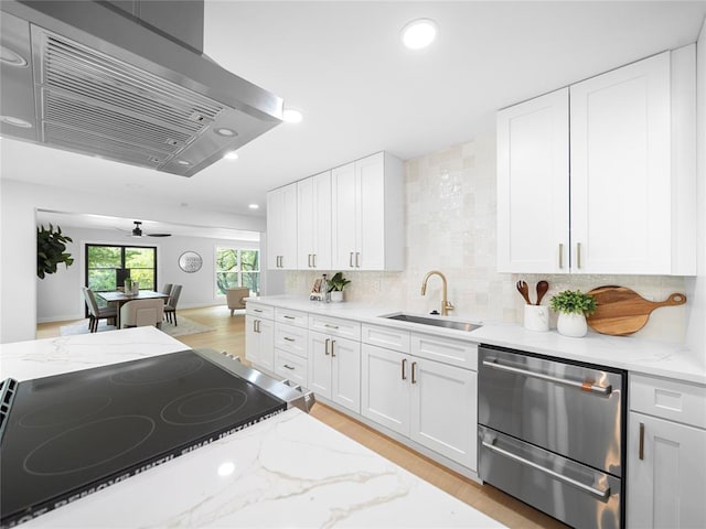 2004 N Cuernavaca Dr, Austin, TX 78733 - kitchen with ventilation hood, stainless steel dishwasher, recessed lighting, white cabinetry, and light stone counters