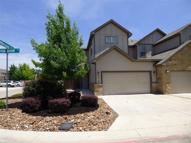 918 Crystal Brook Cv, New Braunfels, TX 78130 - view of front of house featuring stone siding, board and batten siding, an attached garage, and driveway