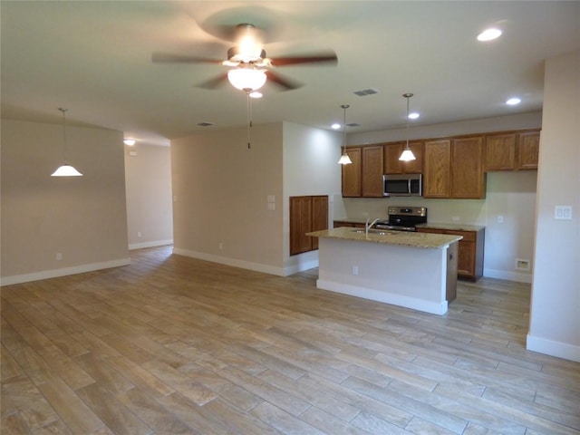 918 Crystal Brook Cv, New Braunfels, TX 78130 - kitchen with stainless steel appliances, brown cabinets, ceiling fan, open floor plan, and decorative light fixtures