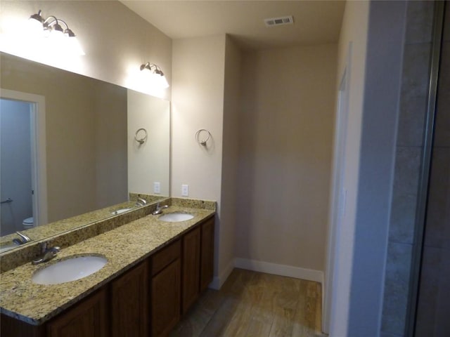 918 Crystal Brook Cv, New Braunfels, TX 78130 - bathroom featuring wood finished floors, baseboards, toilet, and double vanity