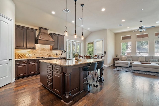 209 Maxwell Way, Austin, TX 78738 - kitchen featuring custom range hood, a sink, recessed lighting, a kitchen bar, and a kitchen island with sink