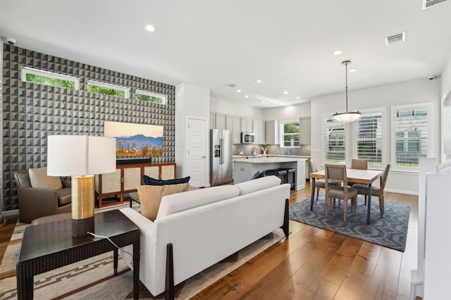 living area with hardwood / wood-style flooring and recessed lighting