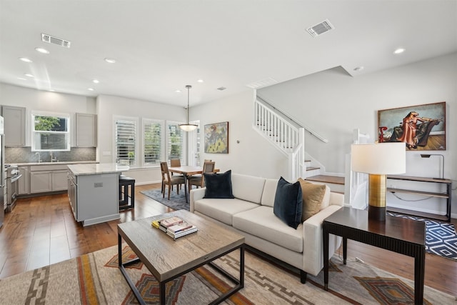 living area with stairs, recessed lighting, and hardwood / wood-style flooring