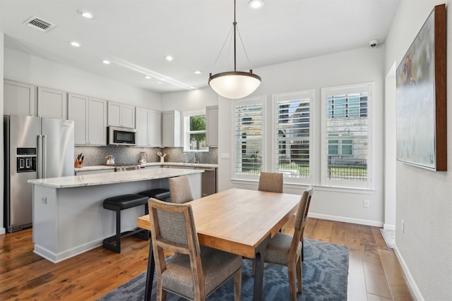 dining space with recessed lighting, wood finished floors, and baseboards