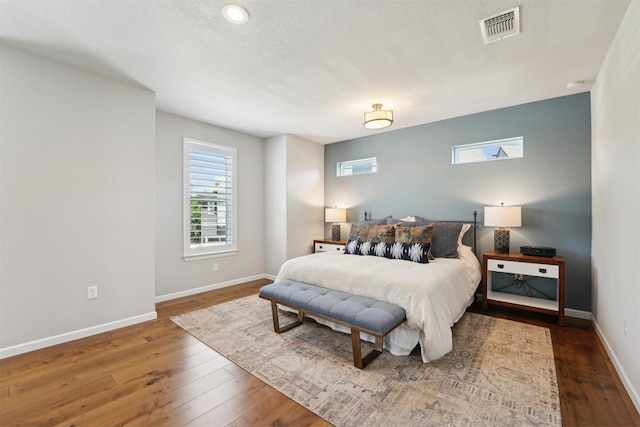 bedroom with wood-type flooring and baseboards