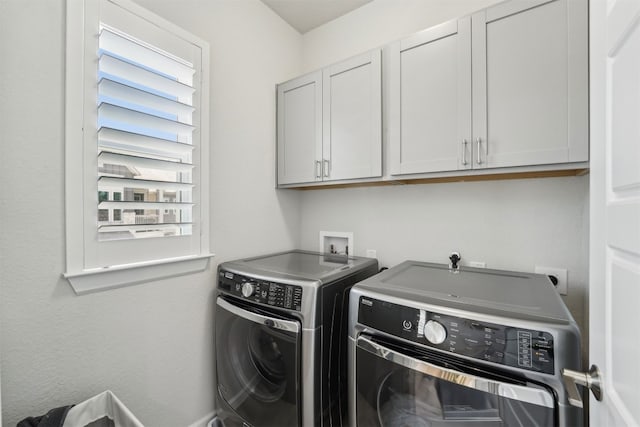 laundry area with cabinet space and separate washer and dryer