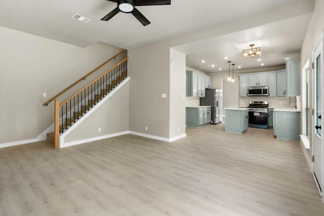 7057 Thistle Hill Way, Austin, TX 78754 - unfurnished living room with light wood-type flooring, stairs, recessed lighting, ceiling fan, and a chandelier