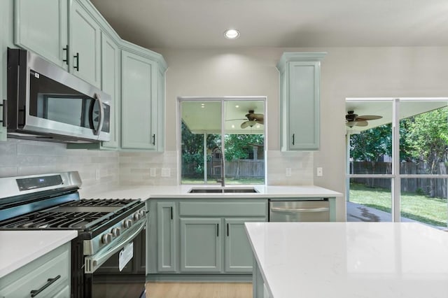 7057 Thistle Hill Way, Austin, TX 78754 - kitchen featuring stainless steel appliances, a sink, light countertops, and backsplash