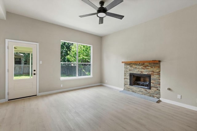 7057 Thistle Hill Way, Austin, TX 78754 - unfurnished living room featuring wood finished floors, ceiling fan, baseboards, and a fireplace