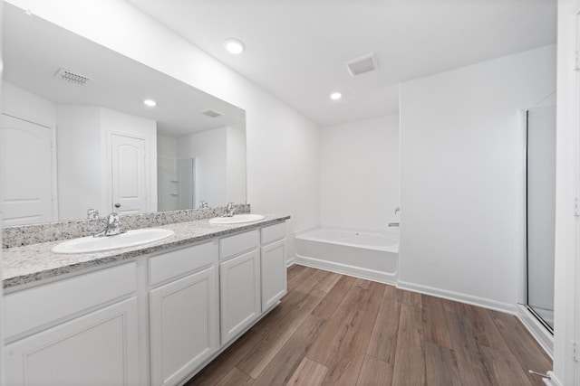 508 Aplite Pass, Maxwell, TX 78656 - full bath featuring wood finished floors, a bath, double vanity, baseboards, and recessed lighting