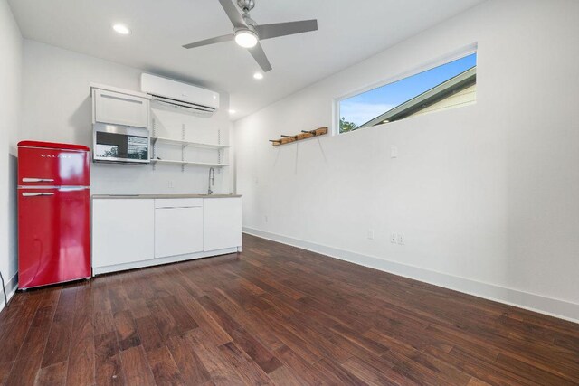 7301 Providence Ave Unit B, Austin, TX 78752 - kitchen with fridge, an AC wall unit, open shelves, stainless steel microwave, and white cabinetry