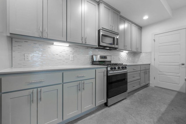 7301 Providence Ave Unit B, Austin, TX 78752 - kitchen featuring stainless steel appliances, gray cabinetry, backsplash, light countertops, and recessed lighting