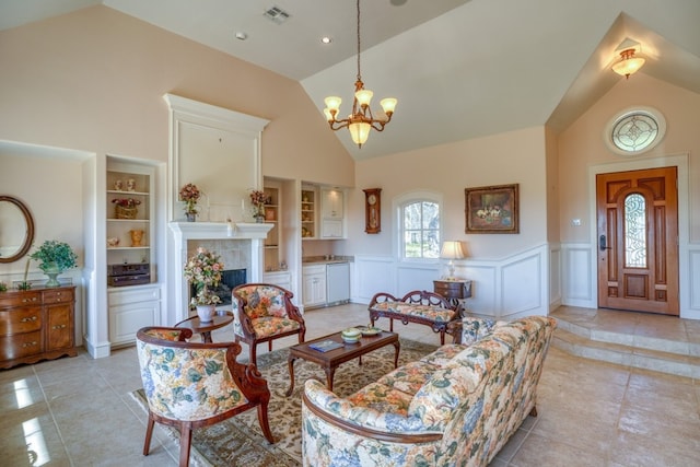 530 Scenic View Dr, Marble Falls, TX 78654 - living area with a wainscoted wall, high vaulted ceiling, light tile patterned floors, a chandelier, and a tiled fireplace