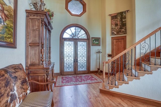 530 Scenic View Dr, Marble Falls, TX 78654 - foyer entrance featuring stairs, wood finished floors, baseboards, french doors, and a towering ceiling