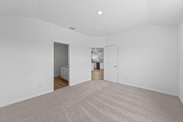 426 Aplite Pass, Maxwell, TX 78656 - unfurnished bedroom featuring light colored carpet, lofted ceiling, baseboards, and connected bathroom