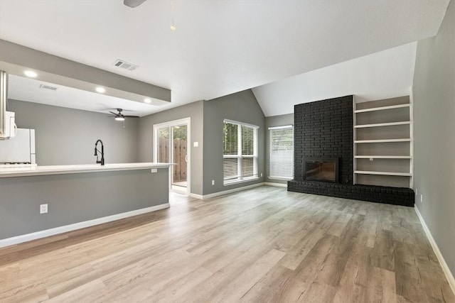 8330 Fathom Cir Unit 404, Austin, TX 78750 - unfurnished living room with ceiling fan, plenty of natural light, light wood finished floors, a brick fireplace, and recessed lighting