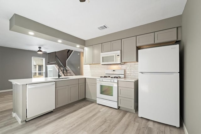8330 Fathom Cir Unit 404, Austin, TX 78750 - kitchen with white appliances, gray cabinets, a peninsula, light countertops, and tasteful backsplash
