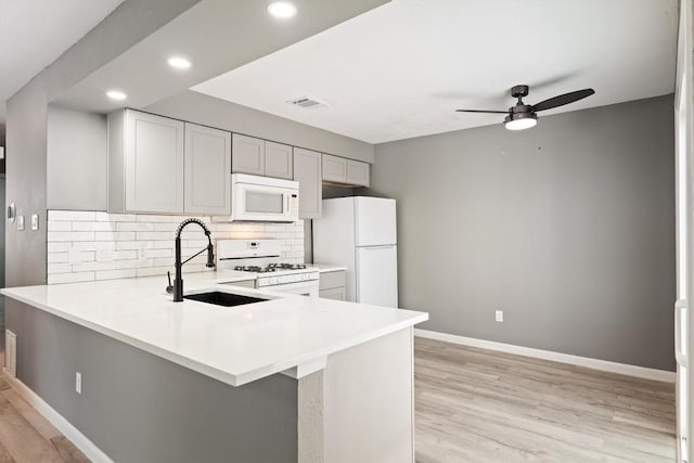 8330 Fathom Cir Unit 404, Austin, TX 78750 - kitchen featuring white appliances, a sink, ceiling fan, decorative backsplash, and light countertops