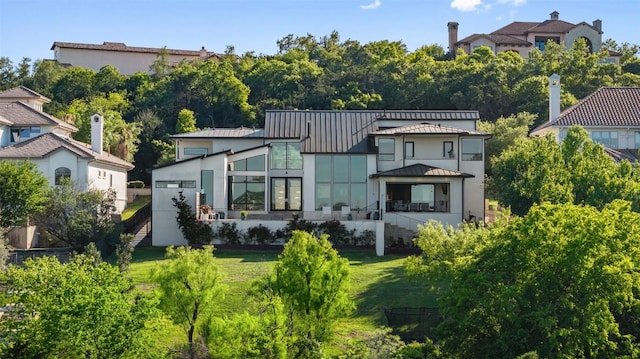 2551 Waymaker Way, Austin, TX 78746 - rear view of property with a standing seam roof, a lawn, metal roof, and stucco siding