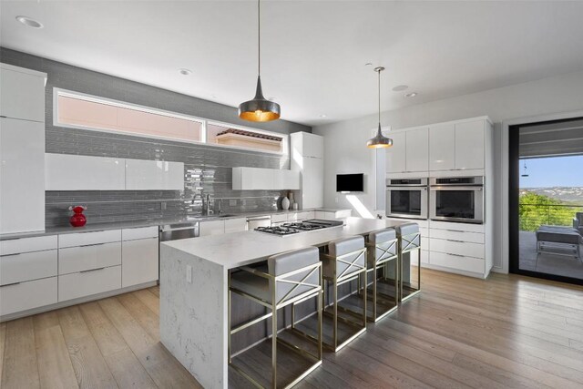 2551 Waymaker Way, Austin, TX 78746 - kitchen featuring stainless steel appliances, modern cabinets, white cabinets, tasteful backsplash, and a kitchen island