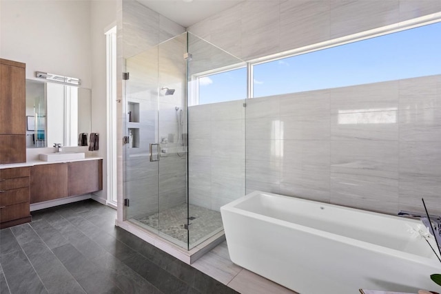 2551 Waymaker Way, Austin, TX 78746 - bathroom featuring vanity, a stall shower, a freestanding tub, and tile patterned floors