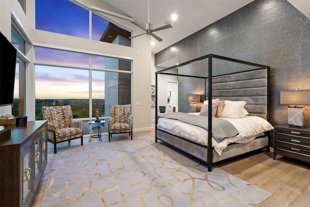 2551 Waymaker Way, Austin, TX 78746 - bedroom featuring wood finished floors, a towering ceiling, and baseboards