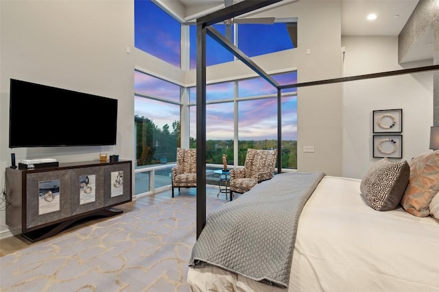 2551 Waymaker Way, Austin, TX 78746 - bedroom with a high ceiling, access to exterior, a wall of windows, and wood finished floors