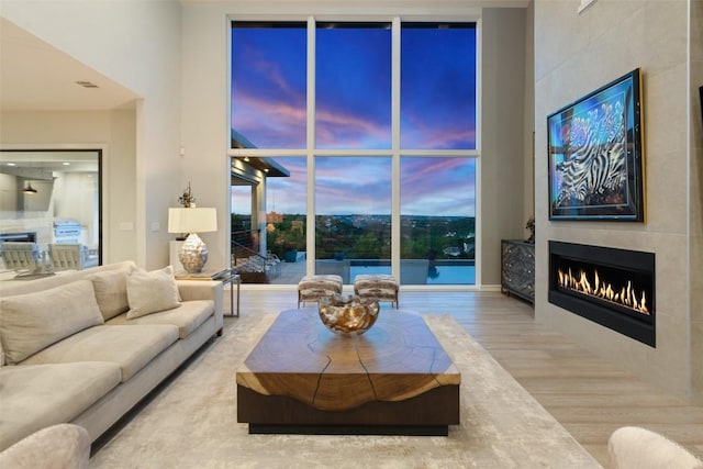 2551 Waymaker Way, Austin, TX 78746 - living area with wood finished floors, a large fireplace, and a wall of windows