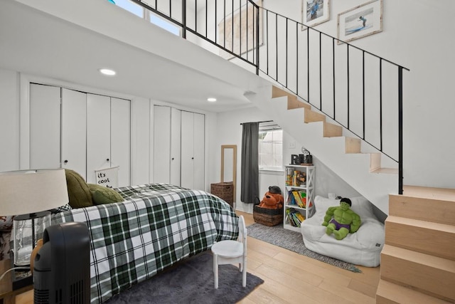 10705 Oak Valley Ct, Austin, TX 78736 - bedroom featuring two closets, wood finished floors, a high ceiling, and recessed lighting