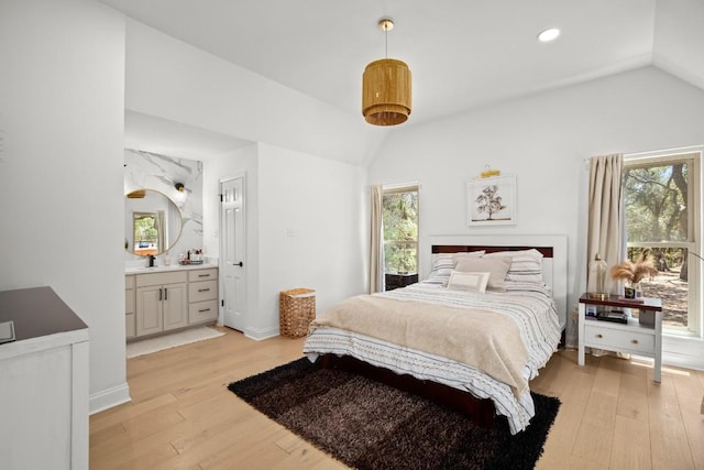10705 Oak Valley Ct, Austin, TX 78736 - bedroom with vaulted ceiling, light wood-type flooring, recessed lighting, connected bathroom, and a sink