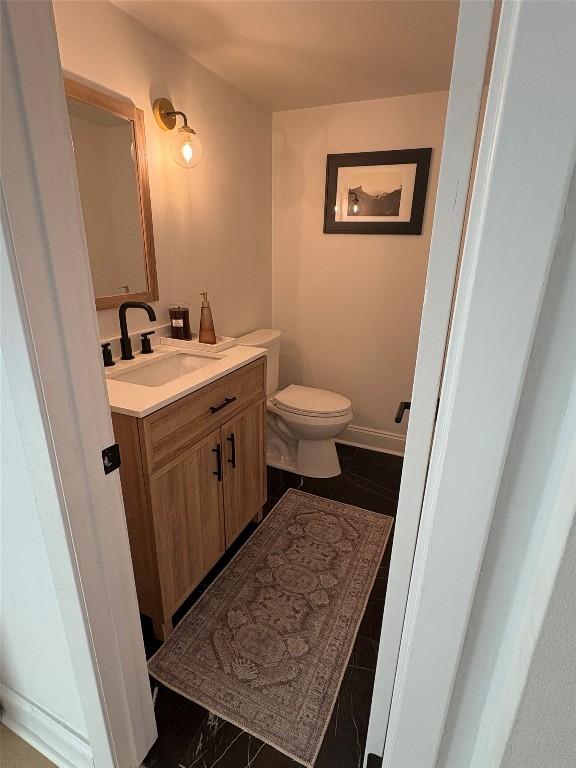 10705 Oak Valley Ct, Austin, TX 78736 - half bathroom featuring vanity, toilet, and baseboards