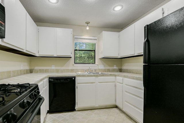 11970 Jollyville Rd Unit 214, Austin, TX 78759 - kitchen featuring black appliances, a sink, tile countertops, a textured ceiling, and white cabinetry