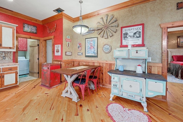 1110 County Road 487, Taylor, TX 76574 - dining space with washer / clothes dryer, crown molding, wood finished floors, and wainscoting