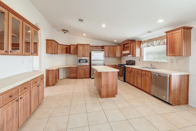 1110 County Road 487, Taylor, TX 76574 - kitchen with stainless steel appliances, a center island, brown cabinets, lofted ceiling, and light countertops