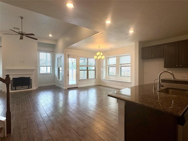 1902 Aves Cv, Pflugerville, TX 78660 - living area with baseboards, a ceiling fan, a chandelier, dark wood-type flooring, and recessed lighting