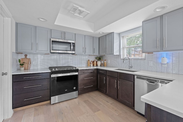 10300 Mourning Dove Dr, Austin, TX 78750 - kitchen with appliances with stainless steel finishes, a sink, light countertops, a tray ceiling, and recessed lighting