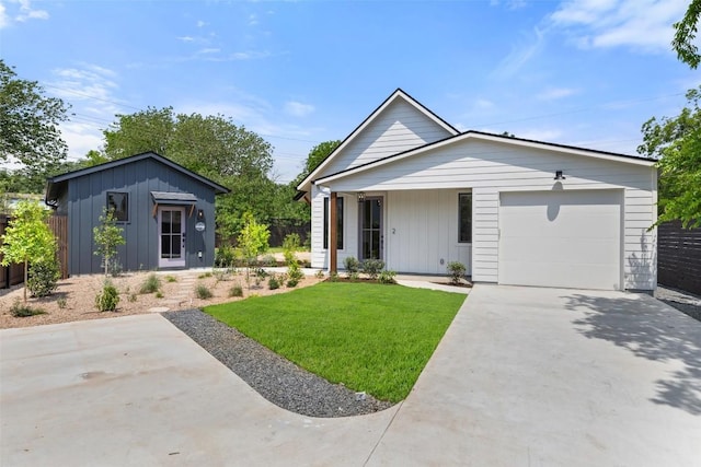 4600 Parkdale Pl, Austin, TX 78745 - view of front facade with a front lawn, a garage, board and batten siding, and driveway