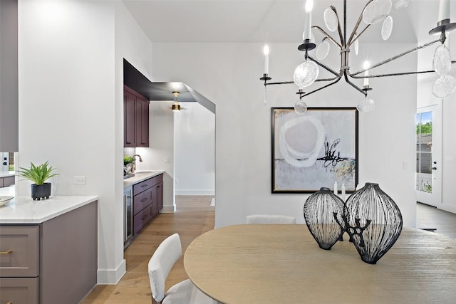 4600 Parkdale Pl, Austin, TX 78745 - dining room with light wood-style floors, a chandelier, wine cooler, and baseboards