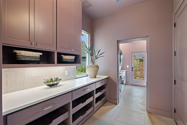 4600 Parkdale Pl, Austin, TX 78745 - kitchen featuring tasteful backsplash, light countertops, light tile patterned floors, gray cabinetry, and washer and clothes dryer