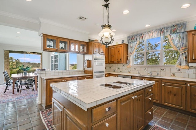 137 Firebird St, Lakeway, TX 78734 - kitchen with white appliances, a sink, a kitchen island, tile countertops, and recessed lighting