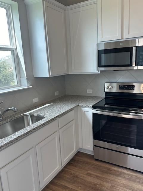 1015 Vista View Dr Unit 101, Georgetown, TX 78626 - kitchen featuring stainless steel appliances, white cabinets, a sink, and backsplash