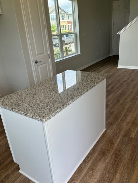 1015 Vista View Dr Unit 101, Georgetown, TX 78626 - kitchen featuring dark wood finished floors, light stone countertops, a kitchen island, and baseboards
