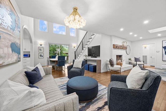 4107 Jefferson St, Austin, TX 78731 - living room featuring a stone fireplace, wood finished floors, recessed lighting, a chandelier, and stairway