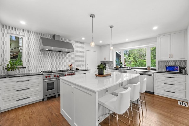 4107 Jefferson St, Austin, TX 78731 - kitchen with appliances with stainless steel finishes, wall chimney exhaust hood, backsplash, white cabinets, and a sink