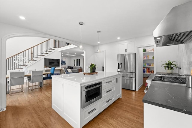 4107 Jefferson St, Austin, TX 78731 - kitchen with stainless steel fridge, wall chimney range hood, white cabinets, light wood-type flooring, and recessed lighting